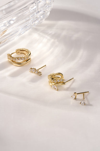 Gold pear stud earrings mixed with hoop and huggie earrings for layered ear styling