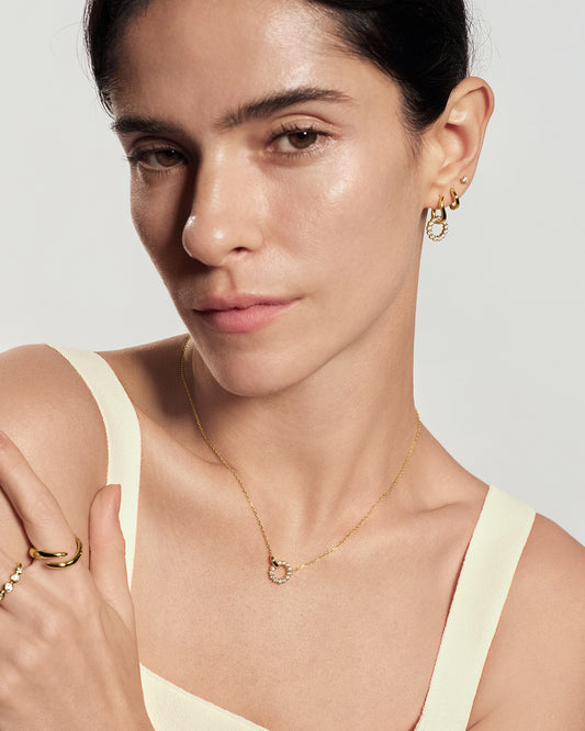 Gold interlinked circles pavé necklace worn on model