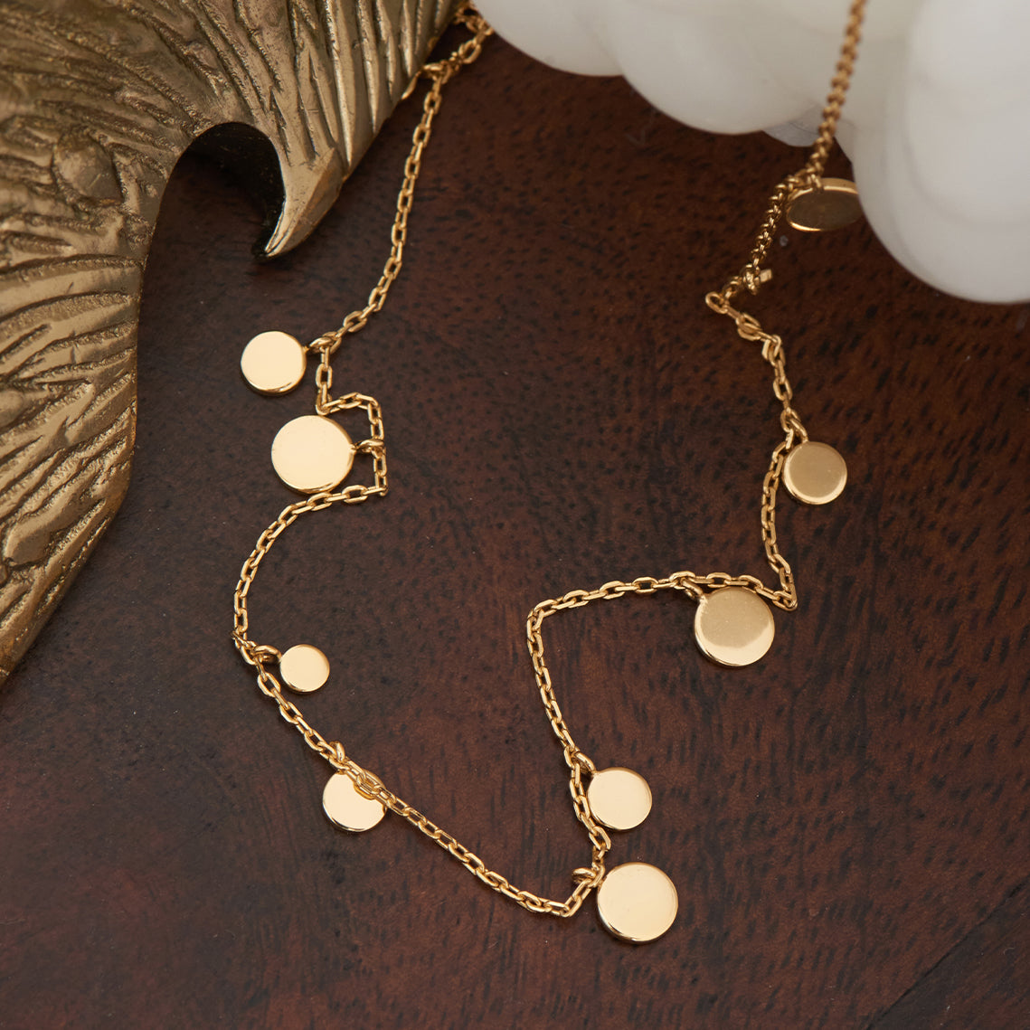 Gold geometric disc necklace on table